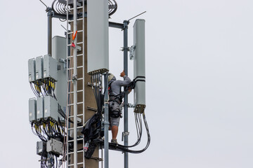 Naklejka premium Telekom technicians perform work on a transmission tower