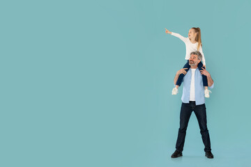 Daddy Holding Daughter On Shoulders, Pointing Finger Aside, Blue Background