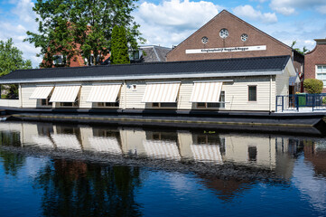 Obraz premium Hasselt, Overijssel, The Netherlands - Wooden houses at the banks of te river, reflecting in the water