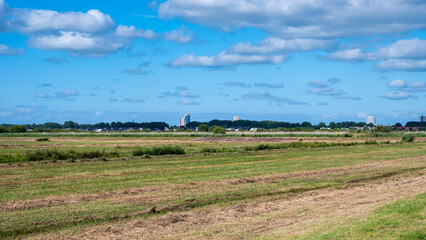 Groningen, The Netherlands, 07 20 2022 - Green fields of the Peizerwering National park with the city of Groningen in the background - obrazy, fototapety, plakaty
