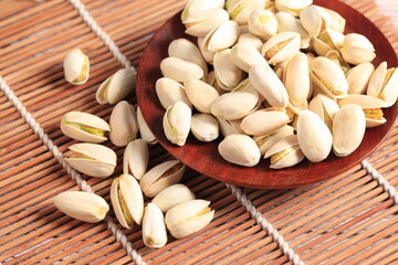 The pistachios are on the wooden board