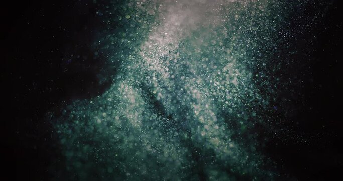 Glitter dust swirl. Particles background. Bokeh light circles texture. Defocused green blue orange bubbles splash on dark black abstract vertical overlay. Shot on RED Cinema camera.