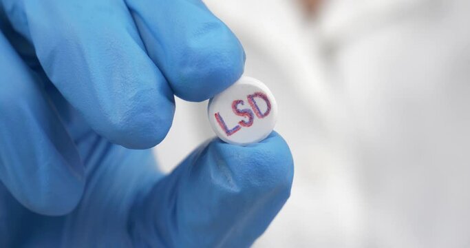 psychedelic lsd tablet in the hands of a medic. High quality 4k footage