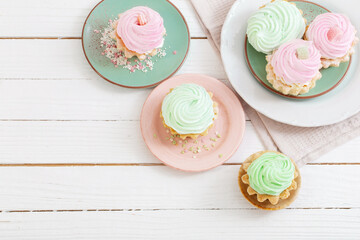 cupcakes on plates on white wooden background