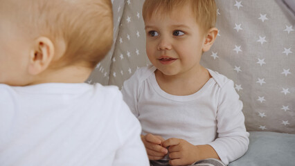 cute toddler siblings playing together in baby wigwam © LIGHTFIELD STUDIOS