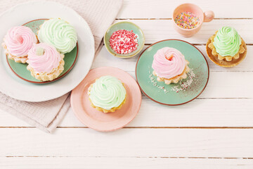 cupcakes on plates on white wooden background