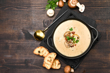 Mushroom soup with bread and fresh mushrooms on a wooden background