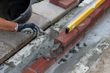Close up photo of male hands holding red brick. Construction site concept. Professional build brick wall. 