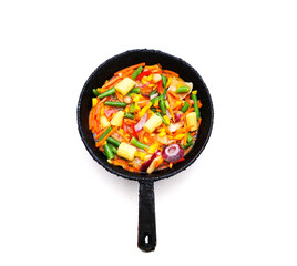 Vegetable mix for proper nutrition in an authentic frying pan on a light background. The concept of organic products or World Vegan Day. 