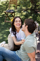 Naklejka premium Cheerful woman touching boyfriend on terrace outdoors