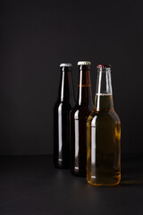 bottles with craft beer on a black background.  Ale or lager from pilsner malt.  homemade home-brewed beer. - obrazy, fototapety, plakaty