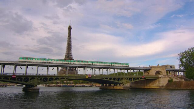 Iron bridge over the river in Paris near the metal tower on which the Paris metro passes. Metro train over Bir-Hakeim bridge and the Eiffel Tower