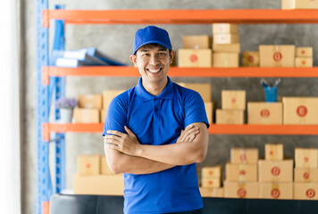 An Asian delivery man is working inside a warehouse. Delivery and service concept