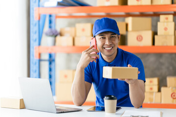 An Asian delivery man is working inside a warehouse. Delivery and service concept
