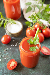 Autumn vitamin drink juice tomato. Tomato juice in a glass and fresh tomatoes on a stone tabetop.