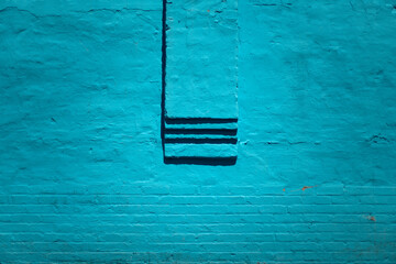 Blue teal concrete textured wall with bricks and ledger