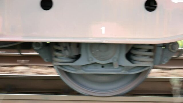 A close-up of the rolling wagon bogies and the spinning wheels on the track. Camera movement following the movement of the train. 4k clip.