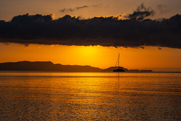 Segelboot vor dem Cap Gerakas bei Sonnenaufgang - obrazy, fototapety, plakaty
