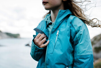 close up of an outdoor jacket on a child whilst walking by the coast