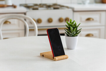 the phone is on a stand on the kitchen table