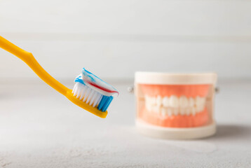 Dentures with a toothbrush on a white background. Upper and lower jaws with false teeth. Dentures or false teeth, close-up. copy space.MOCKUP