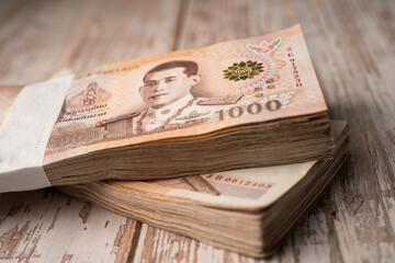 Stack of Thai baht banknotes on wooden background, business saving finance investment concept. - obrazy, fototapety, plakaty