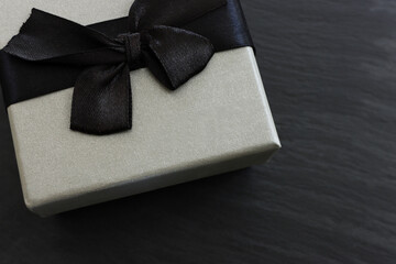 Grey gift box on dark textured background. Top view
