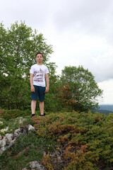 Boy standing on rock on Lago-Naki plateau in summer