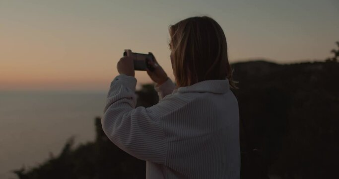 Woman outdoor photography sea on smartphone. Girl shooting on mobile phone