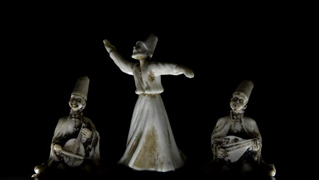 miniature decorative mystic dance whirling in trance with two musicians sitting dark black background low key