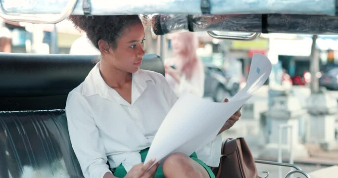 Portrait of tourist, teen girl sit on seat in tuk-tuk, taxi or auto rickshaw at outdoor. To travel planning, review information guide or map. Concept of tourism, transport in Chiang Mai of Thailand.
