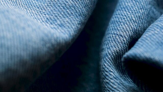 Closeup wrinkled jeans texture. Denim background macro shot footage