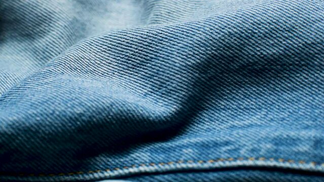 Closeup wrinkled jeans texture. Denim background macro shot footage
