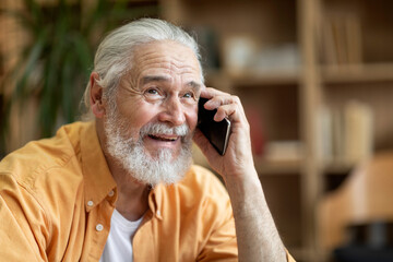 Emotional old man having phone conversation, looking at copy space