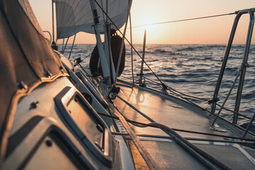 Sailing into the sunset on a yacht traveling through the atlantic ocean
