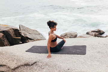 Fototapeta na wymiar Woman doing side turn on mat warming up her body before yoga training