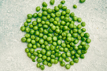 fresh green peas on a gray concrete background