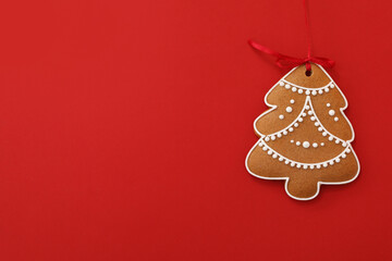 Christmas tree shaped cookie on red background, top view. Space for text