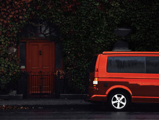 Obraz premium Red minivan parks in front of a house with a red door, ilustration