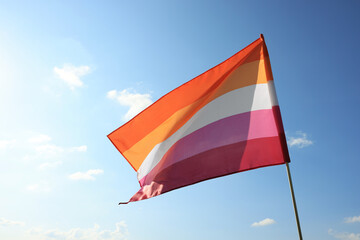 Bright lesbian flag fluttering against blue sky