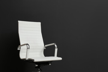 Comfortable office chair on black background. Space for text