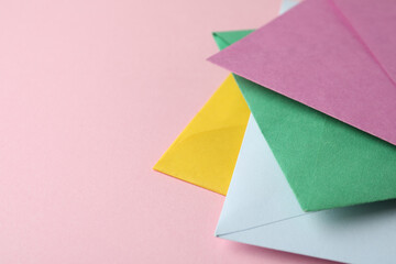 Colorful paper envelopes on pink background, closeup. Space for text