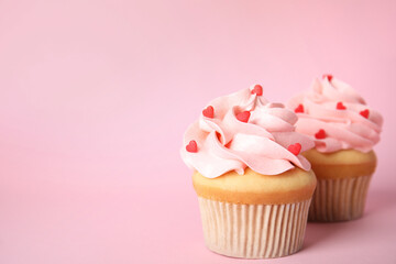 Tasty cupcakes with heart shaped sprinkles on pink background, space for text. Valentine's Day...