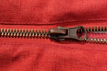 Red fabric with zipper as background, closeup view