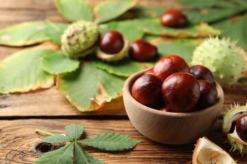 Horse chestnuts and leaves on wooden table - Powered by Adobe