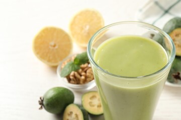 Fresh feijoa smoothie in glass on light table, closeup. Space for text