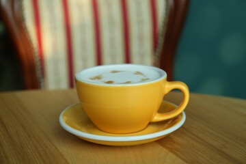 Cup of delicious coffee on wooden table indoors, closeup