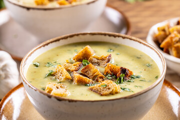 Garlic cream soup with bread croutons in rustic bowl - Close up