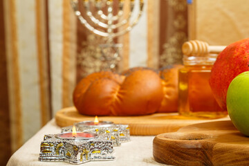 Festive table with ritual traditional dishes and menorah for Rosh Hashanah.