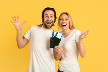 Glad excited millennial caucasian man and lady in white t-shirts with open mouths showing passports with air tickets